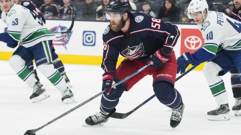 Columbus Blue Jackets defenseman David Savard (58) advances the puck defended by Vancouver Canucks center Elias Pettersson (40) in the third period at Nationwide Arena.