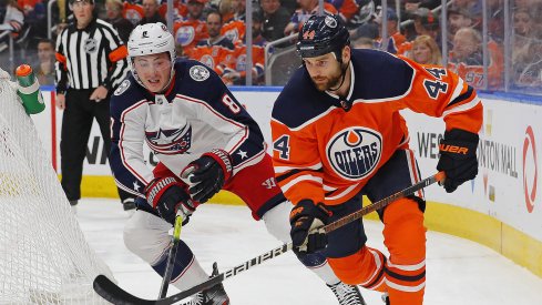 Mar 7, 2020; Edmonton, Alberta, CAN; Columbus Blue Jackets defensemen Zack Werenski (8) and Edmonton Oilers forward Zack Kassian (44) battle for a loose puck during the first period at Rogers Place.