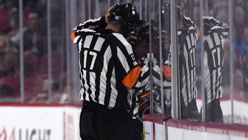 A referee reviews a play in the NHL