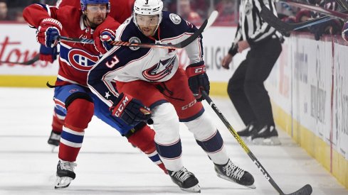 Seth Jones skates down the wall, as Tomas Tatar attempts to slow down his progress.