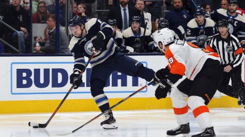 Caption: Nov 27, 2019; Columbus, OH, USA; Columbus Blue Jackets right wing Josh Anderson (77) wrists a shot on goal as Philadelphia Flyers defenseman Ivan Provorov (9) defends during the second period at Nationwide Arena.