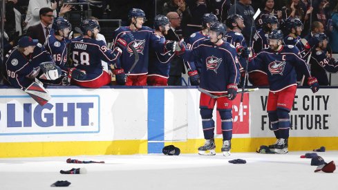 Dec 31, 2019; Columbus, Ohio, USA; Hats begin to hit the ice as Columbus Blue Jackets defenseman Zach Werenski (8) celebrates his first career hat trick during the third period against the Florida Panthers at Nationwide Arena. 