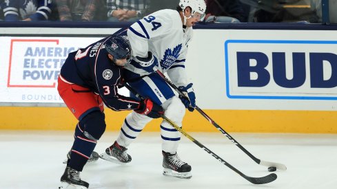 Seth Jones battles for the puck against Auston Matthews 