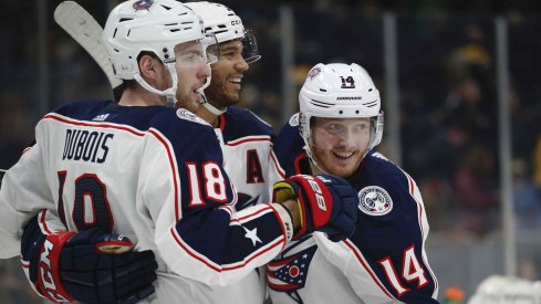 Columbus Blue Jackets center Pierre-Luc Dubois (18) celebrates with defenseman Seth Jones (3) and center Gustav Nyquist (14) after scoring the game winning goal during the overtime period against the Boston Bruins at TD Garden.
