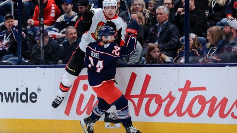 Nathan Gerbe checks Mike Reilly at Nationwide Arena.