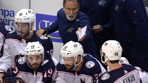 John Tortorella communicates with his players from behind the bench