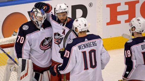 Columbus Blue Jackets goaltender Joonas Korpisalo (70) celebrates with defenseman Seth Jones (3) and center Alexander Wennberg (10) after defeating the Tampa Bay Lightning in game two of the first round of the 2020 Stanley Cup Playoffs at Scotiabank Arena.