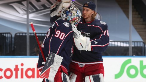 Elvis Merzlikins and Joonas Korpisalo celebrate a win