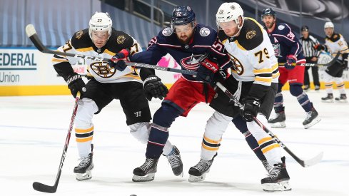 Emil Bemstrom tries to split the Boston Bruins' defense