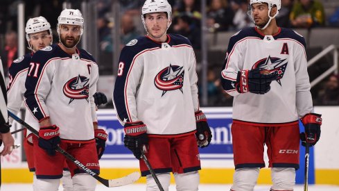 Nick Foligno, Zach Werenski, Seth Jones, and Emil Bemstrom before a faceoff 