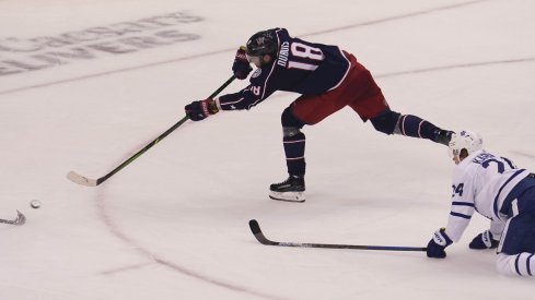 Aug 6, 2020; Toronto, Ontario, CAN; Columbus Blue Jackets forward Pierre-Luc Dubois (18) scores on this shot as Toronto Maple Leafs forward Kasperi Kapanen (24) looks on during the third period of Eastern Conference qualifications at Scotiabank Arena.