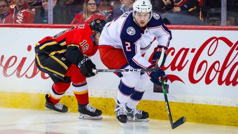 Mar 4, 2020; Calgary, Alberta, CAN; Columbus Blue Jackets defenseman Andrew Peeke (2) and Calgary Flames center Tobias Rieder (16) battle for the puck during the third period at Scotiabank Saddledome.