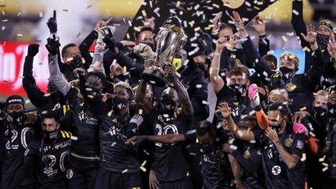  Columbus Crew defender Jonathan Mensah (4) hoists the MLS Cup trophy with his teammates after their 3-0 win over the Seattle Sounders in the MLS Cup at MAPFRE Stadium.