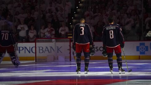 Zach Werenski and Seth Jones during the National Anthem before a game against the Carolina Hurricanes at PNC Arena