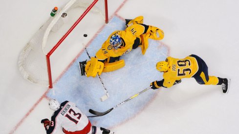 Columbus Blue Jackets forward Cam Atkinson scores against Nashville Predators goaltender Juuse Saros during a game at Bridgestone Arena.