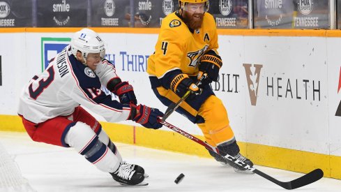 Jan 16, 2021; Nashville, Tennessee, USA; Nashville Predators defenseman Ryan Ellis (4) hits the puck past Columbus Blue Jackets right wing Cam Atkinson (13) during the second period at Bridgestone Arena.