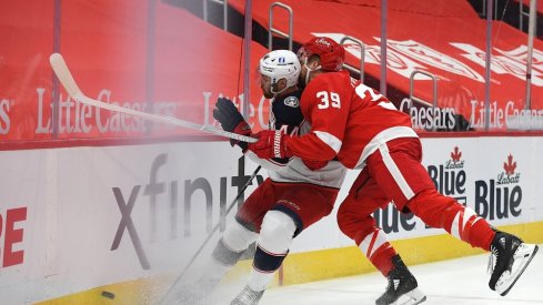 Detroit Red Wings right wing Anthony Mantha (39) checks Columbus Blue Jackets defenseman Vladislav Gavrikov (44) during the second period at Little Caesars Arena.