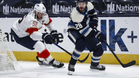 Jan 26, 2021; Columbus, Ohio, USA; Florida Panthers center Aleksander Barkov (16) skates as Columbus Blue Jackets right wing Oliver Bjorkstrand (28) passes the puck in the first period at Nationwide Arena.