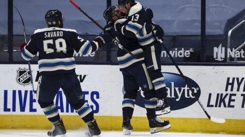 Jan 26, 2021; Columbus, Ohio, USA; Columbus Blue Jackets right wing Cam Atkinson (13) leaps into the arms of left wing Nick Foligno (71) to celebrate scoring a goal against the Florida Panthers in the third period at Nationwide Arena.