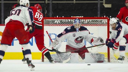 Feb 15, 2021; Raleigh, North Carolina, USA; Carolina Hurricanes center Martin Necas (88) and Columbus Blue Jackets goaltender Elvis Merzlikins (90) watch the puck during the third period at PNC Arena.