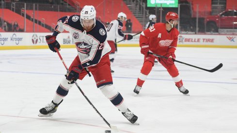 Jan 18, 2021; Detroit, Michigan, USA; Columbus Blue Jackets center Mikhail Grigorenko (25) brings the puck up ice against the Detroit Red Wings during the first period at Little Caesars Arena.