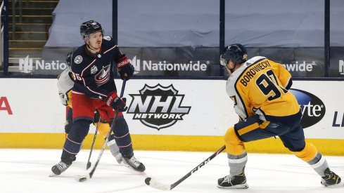 Columbus Blue Jackets center Jack Roslovic (96) wrists a shot on goal as Nashville Predators defenseman Mark Borowiecki (90) defends during the third period at Nationwide Arena. 