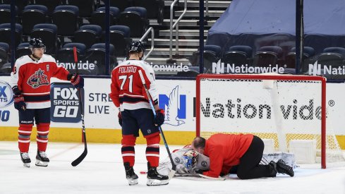 Feb 20, 2021; Columbus, Ohio, USA; Columbus Blue Jackets goaltender Elvis Merzlikins (90) is looked after by Columbus head athletic trainer Mike Vogt (right) during a stop in play against the Nashville Predators in the third period at Nationwide Arena.