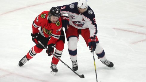 Chicago Blackhawks left wing Brandon Hagel (38) and Columbus Blue Jackets defenseman Seth Jones (3) fight for the puck during the second period at the United Center.