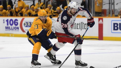 Feb 27, 2021; Nashville, Tennessee, USA; Columbus Blue Jackets right wing Oliver Bjorkstrand (28) takes a shot on goal against Nashville Predators right wing Rocco Grimaldi (23) during the second period at Bridgestone Arena.