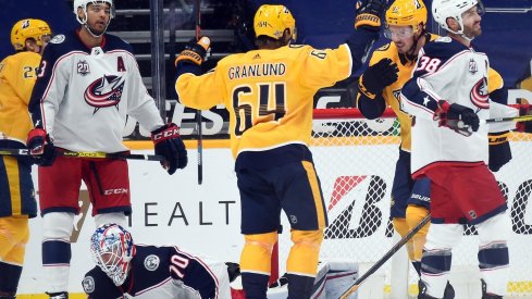 Nashville Predators center Mikael Granlund (64) and center Ryan Johansen (92) celebrate after a goal by right wing Eeli Tolvanen (28) past Columbus Blue Jackets goaltender Joonas Korpisalo (70) during the second period at Bridgestone Arena.