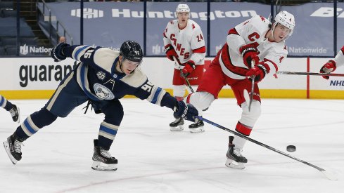 Carolina Hurricanes defenseman Haydn Fleury (4) clears the puck as Columbus Blue Jackets center Jack Roslovic (96) deflects the puck during the third period at Nationwide Arena.