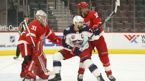 Columbus Blue Jackets left wing Nick Foligno (71) and Detroit Red Wings defenseman Marc Staal (18) fight for position with in front of goaltender Calvin Pickard (31) in the first period at Little Caesars Arena.