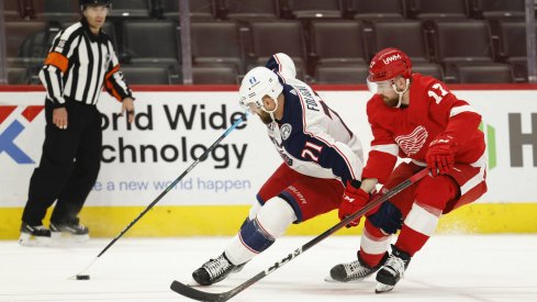 Mar 27, 2021; Detroit, Michigan, USA; Columbus Blue Jackets left wing Nick Foligno (71) skates with the puck defended by Detroit Red Wings defenseman Filip Hronek (17) in the third period at Little Caesars Arena.