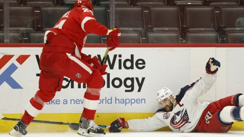 Jon Merrill and Nick Foligno battle for the puck