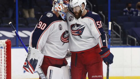 Mar 30, 2021; Tampa, Florida, USA; Columbus Blue Jackets goaltender Elvis Merzlikins (90) and defenseman David Savard (58) celebrate after defeating the Tampa Bay Lightning at Amalie Arena.