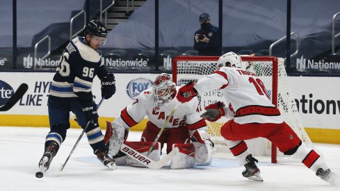 Columbus Blue Jackets forward Jack Roslovic fights for the pick against Carolina Hurricanes forward Vincent Trocheck during a game at Nationwide Arena.