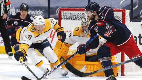 May 5, 2021; Columbus, Ohio, USA; Columbus Blue Jackets right wing Oliver Bjorkstrand (28) passes the puck as Nashville Predators right wing Eeli Tolvanen (28) reaches for the steal during the first period at Nationwide Arena.