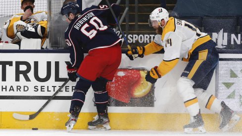 May 5, 2021; Columbus, Ohio, USA; Columbus Blue Jackets left wing Eric Robinson (50) and Nashville Predators defenseman Mattias Ekholm (14) battle for the puck during the first period at Nationwide Arena.