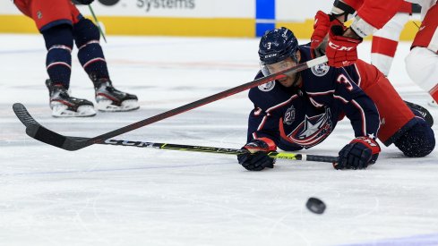 Columbus Blue Jackets defenseman Seth Jones (3) passes the puck as he falls to the ice against Detroit Red Wings center Luke Glendening (41) in the third period at Nationwide Arena.