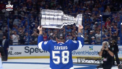 David Savard lifts the Stanley Cup above his shoulders.