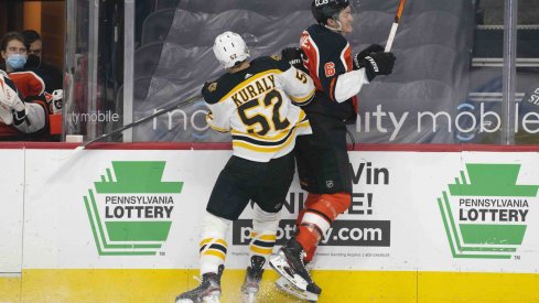 Apr 10, 2021; Philadelphia, Pennsylvania, USA; Boston Bruins center Sean Kuraly (52) checks Philadelphia Flyers defenseman Travis Sanheim (6) into the boards in the first period at the Wells Fargo Center.