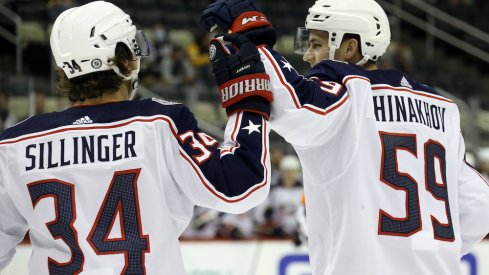 Columbus Blue Jackets forward Yegor Chinakhov (59) celebrates with forward Cole Sillinger (34) after scoring a goal against the Pittsburgh Penguins during the first period at PPG Paints Arena.