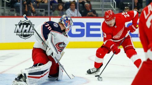 Oct 19, 2021; Detroit, Michigan, USA; Detroit Red Wings right wing Lucas Raymond (23) tries to score on Columbus Blue Jackets goaltender Joonas Korpisalo (70) in the second period at Little Caesars Arena. 