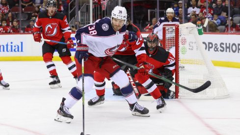 Oct 31, 2021; Newark, New Jersey, USA; Columbus Blue Jackets center Boone Jenner (38) plays the puck while being defended by New Jersey Devils defenseman Ty Smith (24) during the first period at Prudential Center.