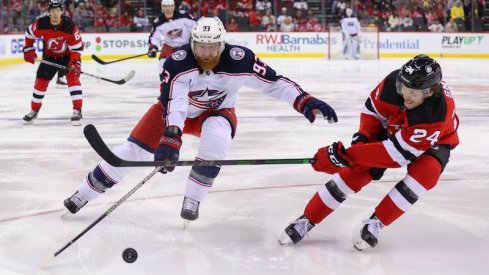 Jakub Voracek fights for the puck against the New Jersey Devils.