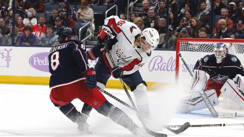 Nov 12, 2021; Columbus, Ohio, USA; Columbus Blue Jackets defenseman Zach Werenski (8) sticks a rebound away from Washington Capitals left wing Axel Johnson-Fjallby (45) during the second period at Nationwide Arena