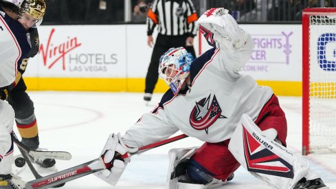 Elvis Merzlikins of the Columbus Blue Jackets reaches for the puck against the Vegas Golden Knights at T-Mobile Arena.