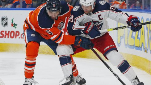 Columbus Blue Jackets' Boone Jenner battles a loose puck against Edmonton Oilers' Cody Ceci at Rogers Place in Edmonton.