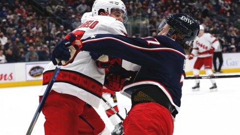 Jan 1, 2022; Columbus, Ohio, USA; Carolina Hurricanes defenseman Tony DeAngelo (77) checks Columbus Blue Jackets defenseman Adam Boqvist (27) during the second period at Nationwide Arena.