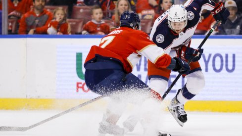 Columbus Blue Jackets defenseman Andrew Peeke skates with the puck against Florida Panthers defenseman Radko Gudas in the first period at FLA Live Arena.